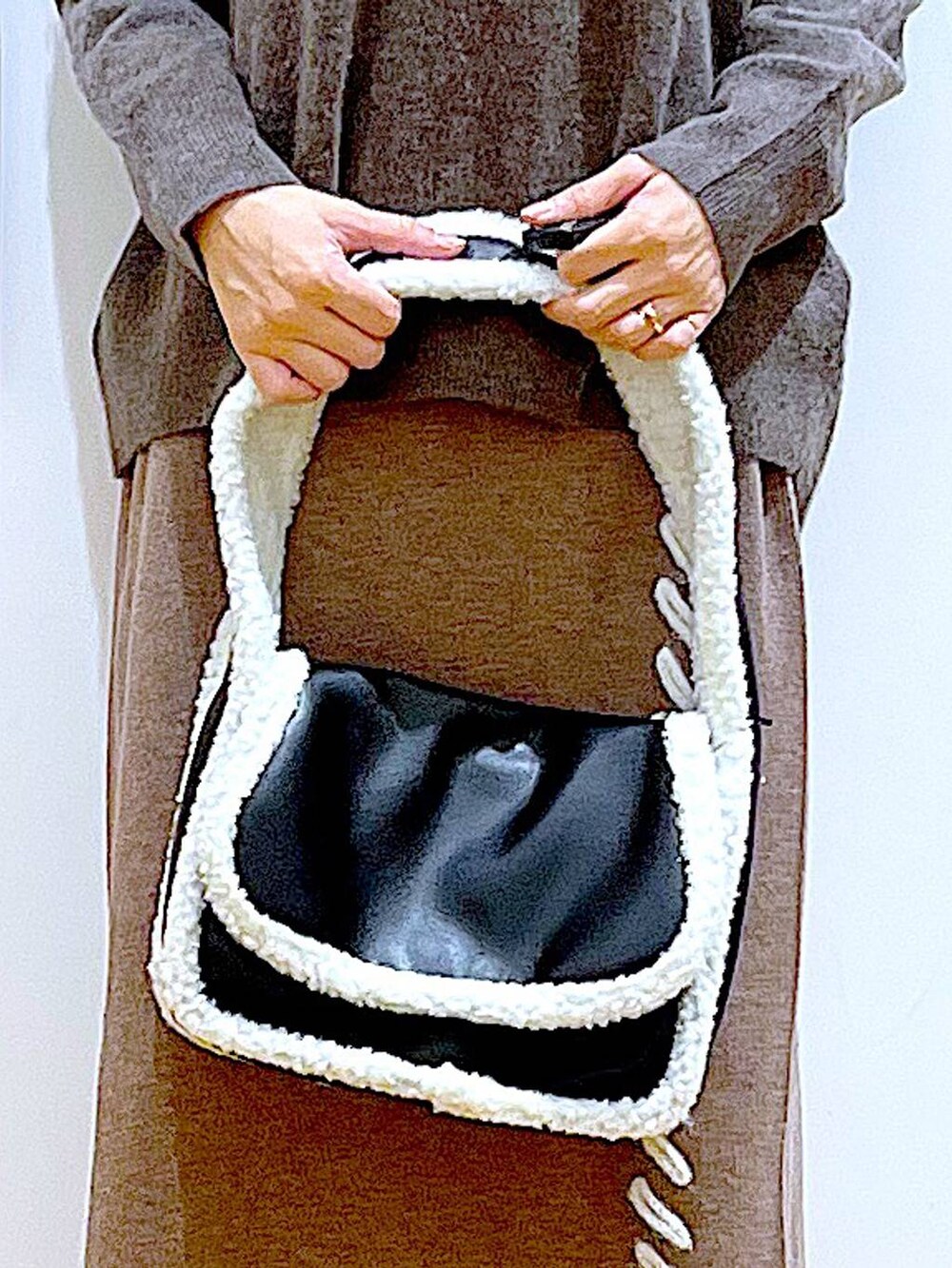 ブラウン系のニット/セーター、ブラック系のショルダーバッグ、ブラック系のブーツを着用したレディースの冬コーディネートの9枚目の写真