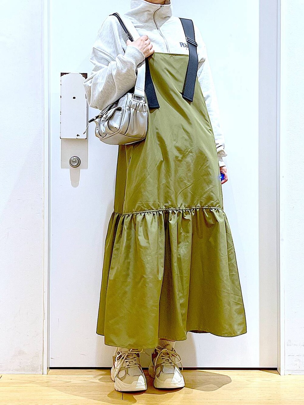 ベージュ系のスウェット、ベージュ系のスニーカー、シルバー系のショルダーバッグを着用したレディースの春コーディネートの6枚目の写真