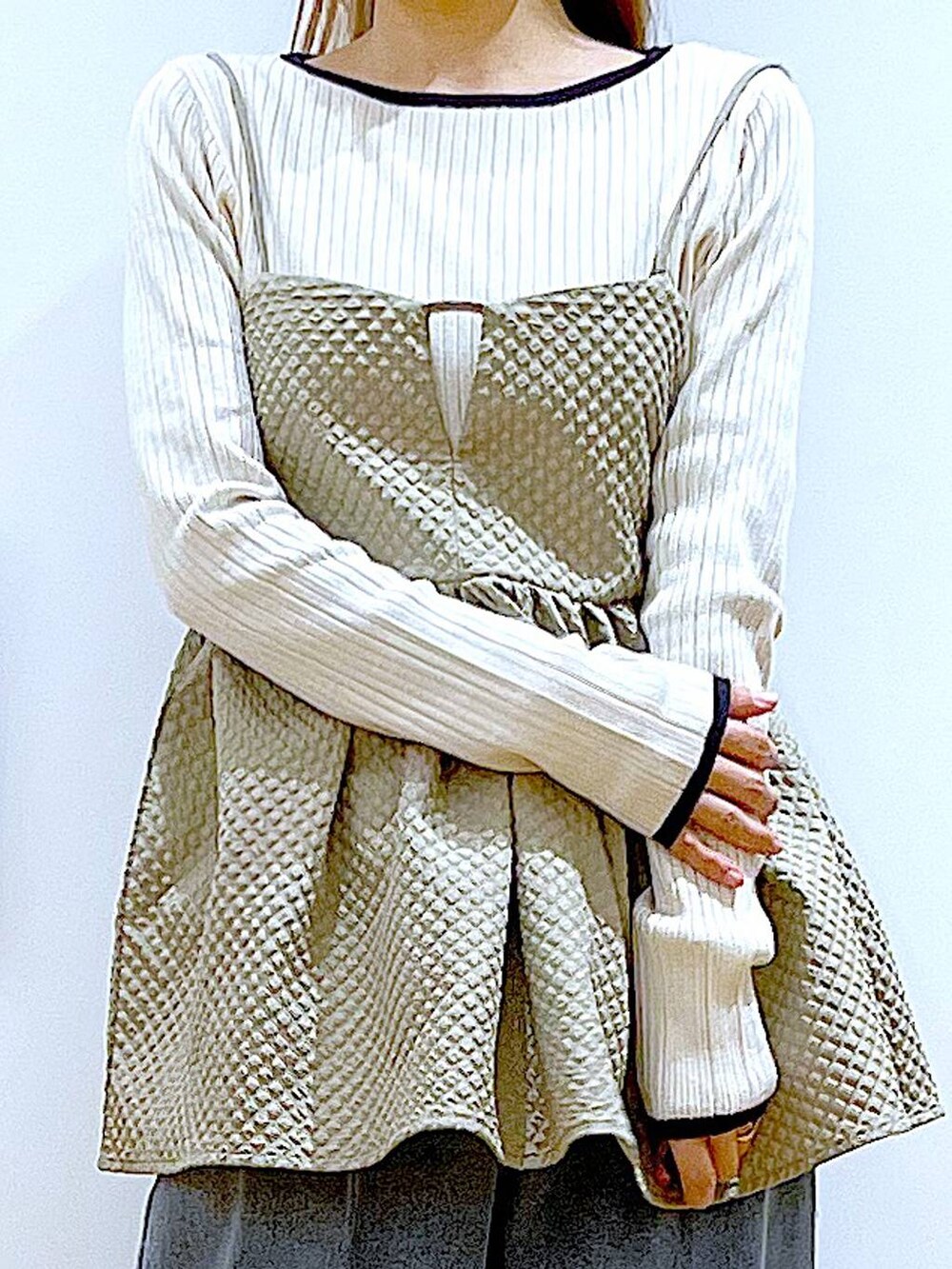 ブルー系のショルダーバッグ、ブルー系のデニムパンツ、ベージュ系のニット/セーターを着用したレディースの春コーディネートの7枚目の写真