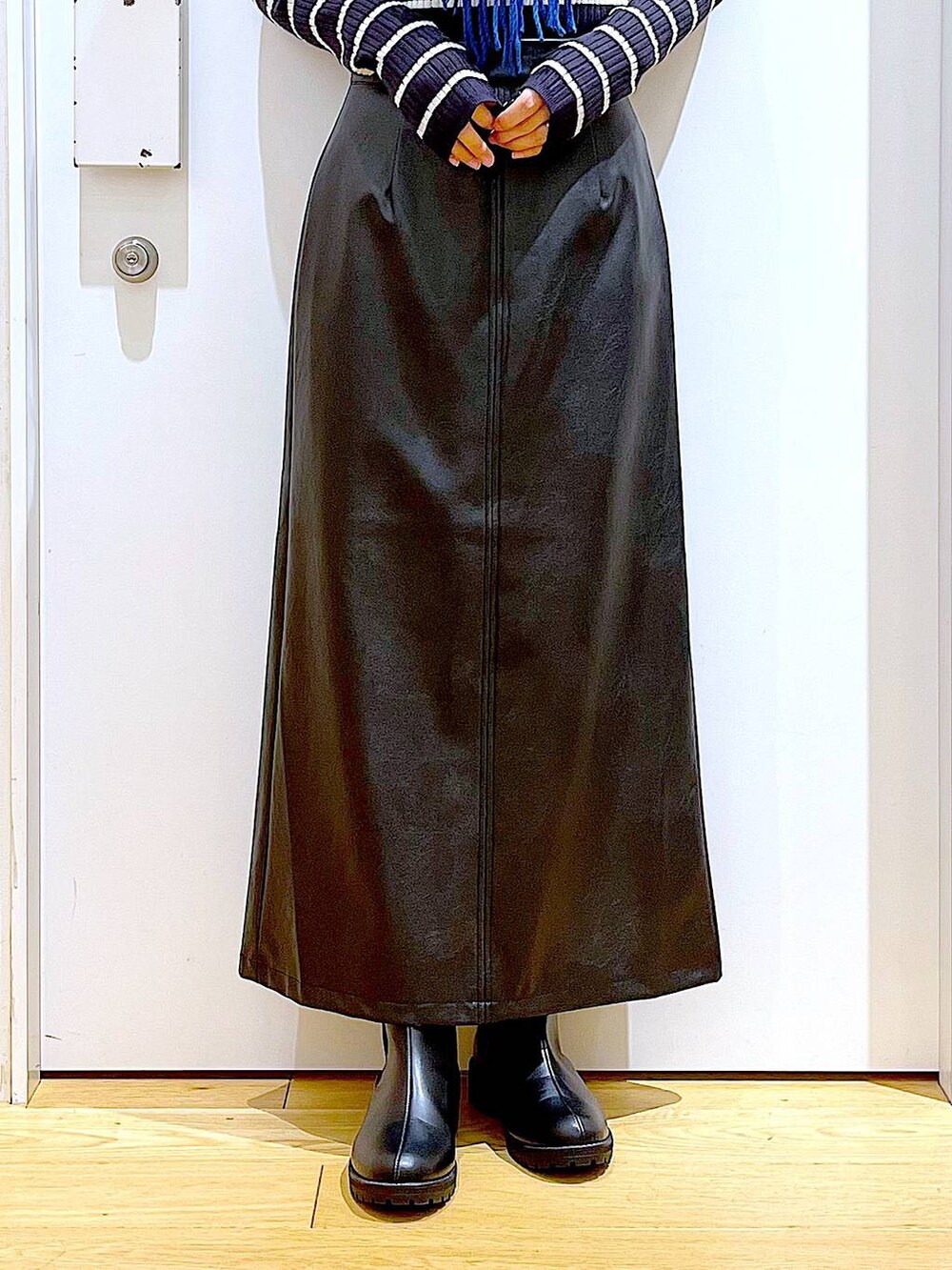 ブラック系のブーツ、ブルー系のニット/セーター、シルバー系のショルダーバッグを着用したレディースの冬コーディネートの8枚目の写真