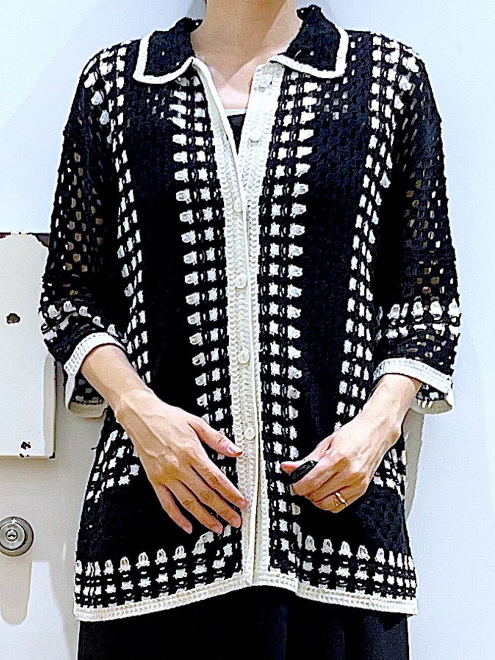 シルバー系のショルダーバッグ、ブラック系のパンプス、ブラック系のワンピースを着用したレディースの春コーディネートの7枚目の写真