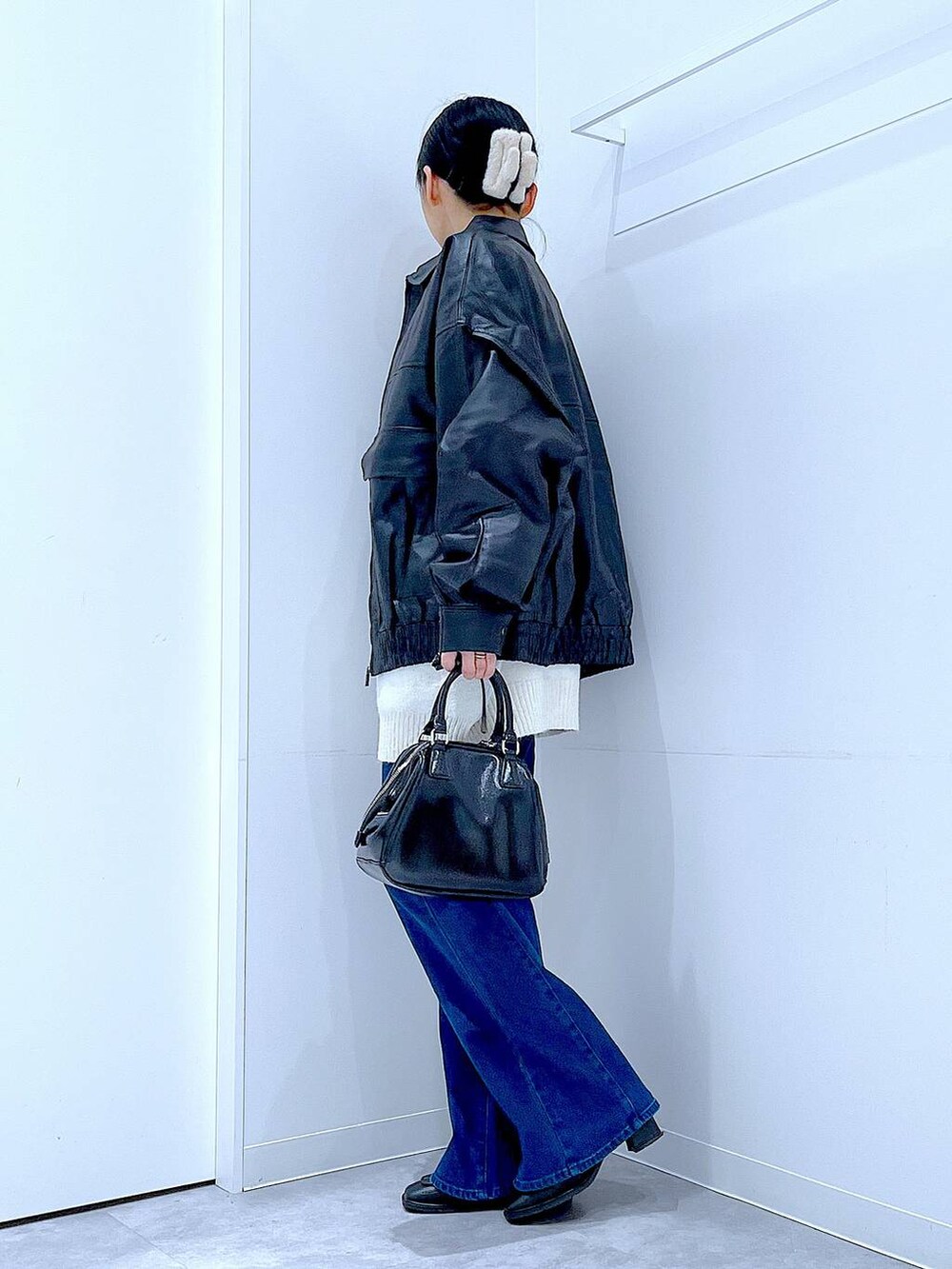 ブラック系のブルゾン、ブラック系のブーツ、ブラック系のショルダーバッグを着用したレディースの冬コーディネートの3枚目の写真