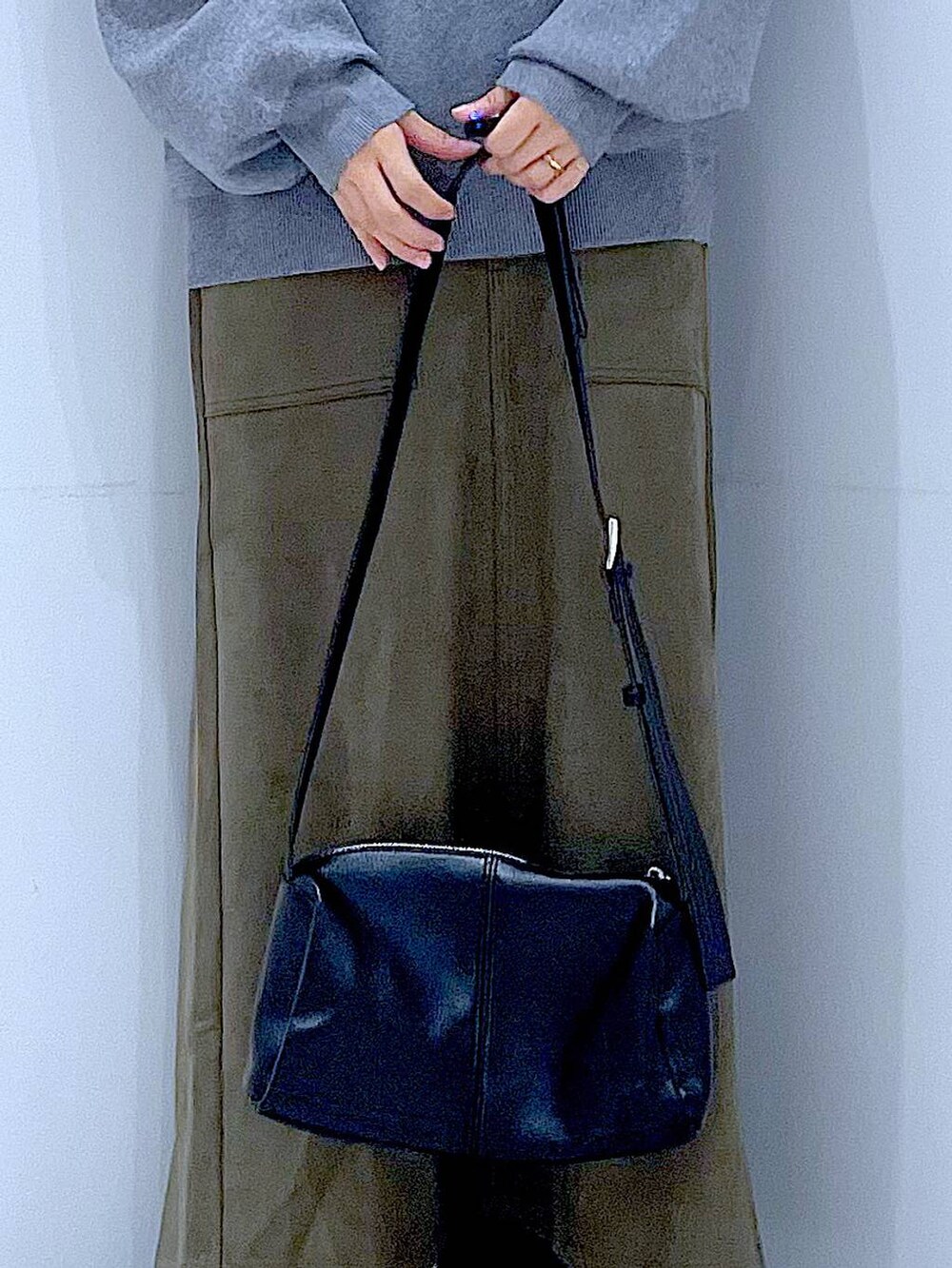 ブラック系のショルダーバッグ、ブラック系のブーツ、グリーン系のスカートを着用したレディースの冬コーディネートの9枚目の写真