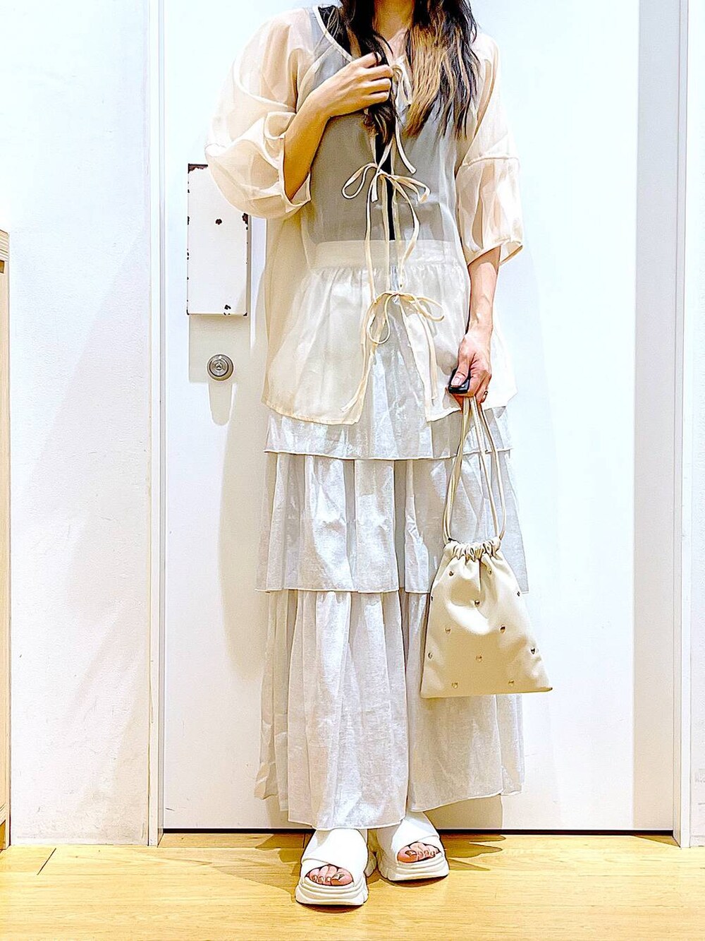 ホワイト系のサンダル、ブラック系のニット/セーター、ホワイト系のショルダーバッグを着用したレディースの夏コーディネートの6枚目の写真