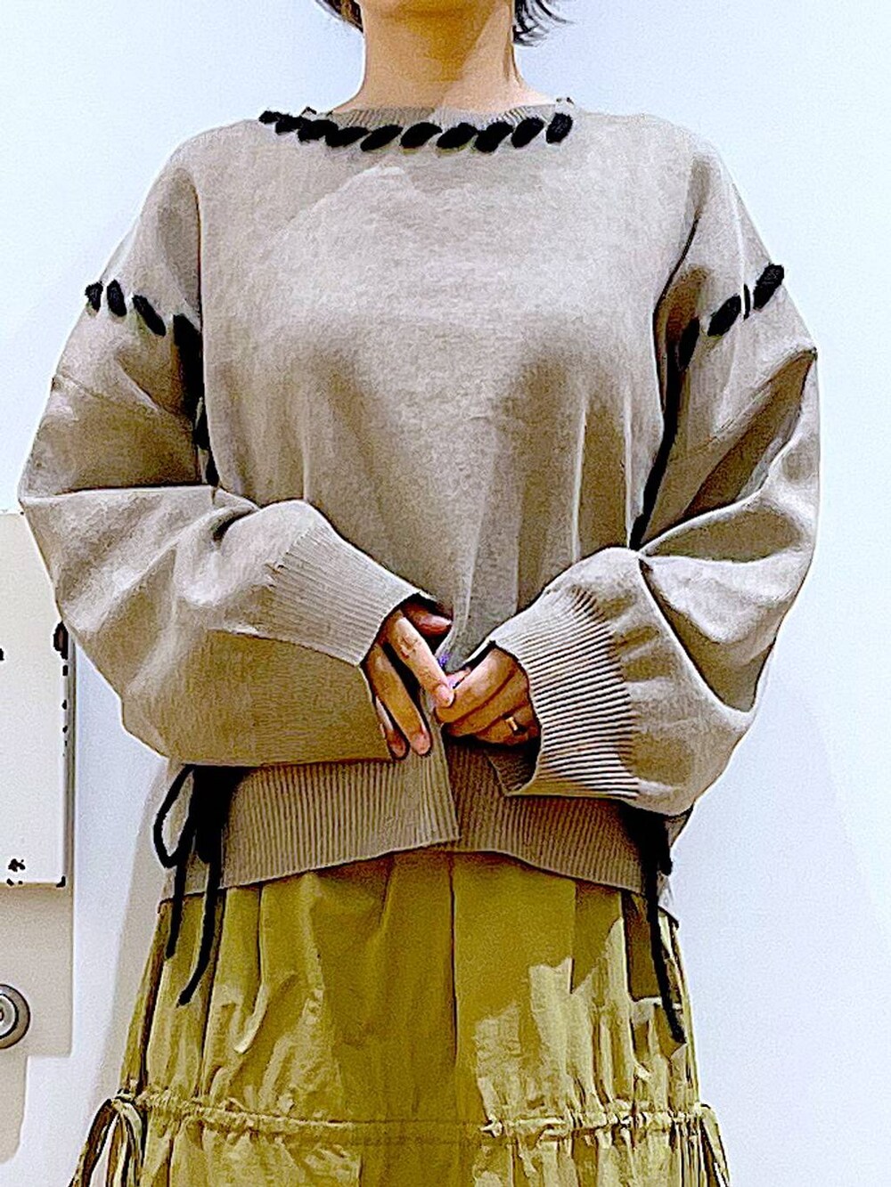 ホワイト系のショルダーバッグ、イエロー系のスカート、ベージュ系のブーツを着用したレディースの秋コーディネートの7枚目の写真