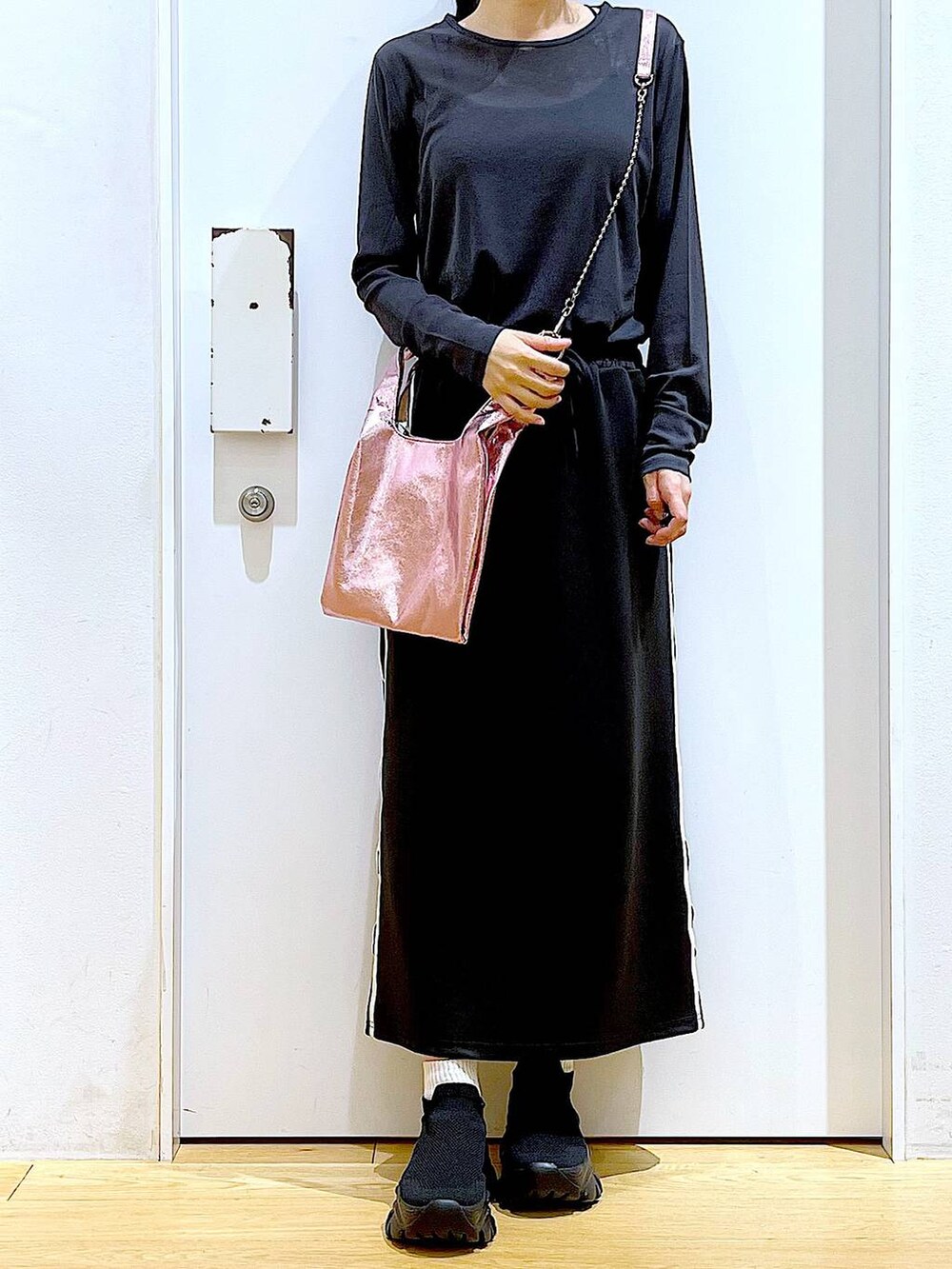 ブラック系のスカート、ピンク系のショルダーバッグ、ブラック系のスニーカーを着用したレディースの春コーディネートの6枚目の写真