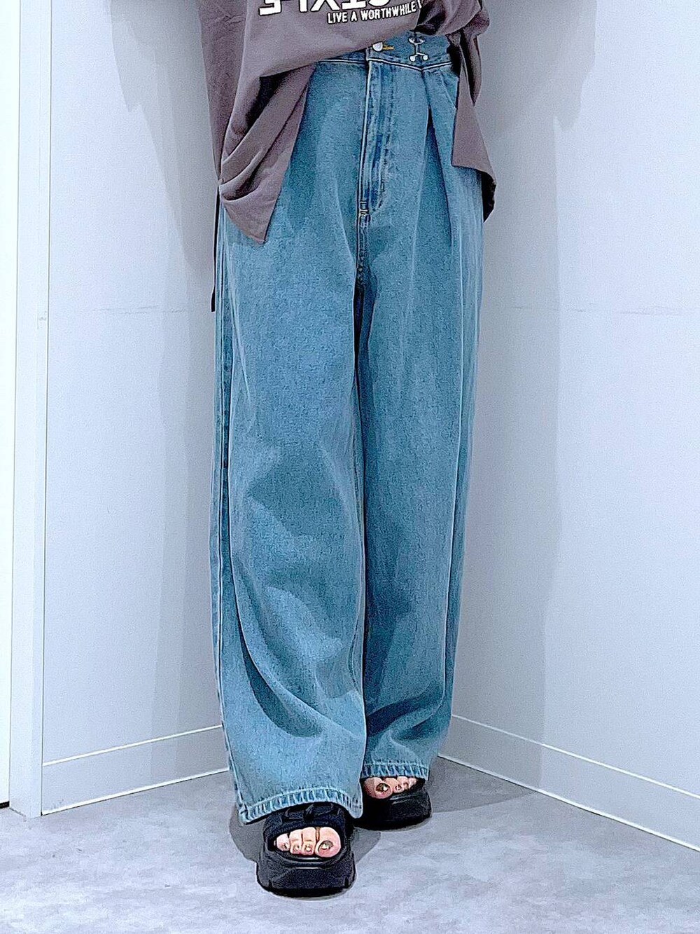 ブラック系のショルダーバッグ、ブラック系のスニーカー、ブルー系のデニムパンツを着用したレディースの秋コーディネートの8枚目の写真