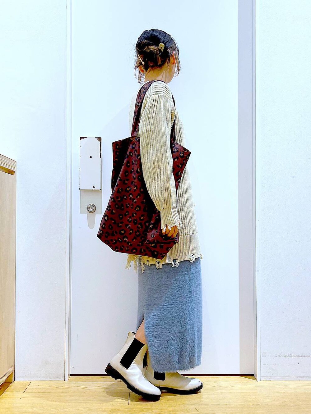 ベージュ系のブーツ、その他のトートバッグ、ブルー系のスカートを着用したレディースの冬コーディネートの4枚目の写真