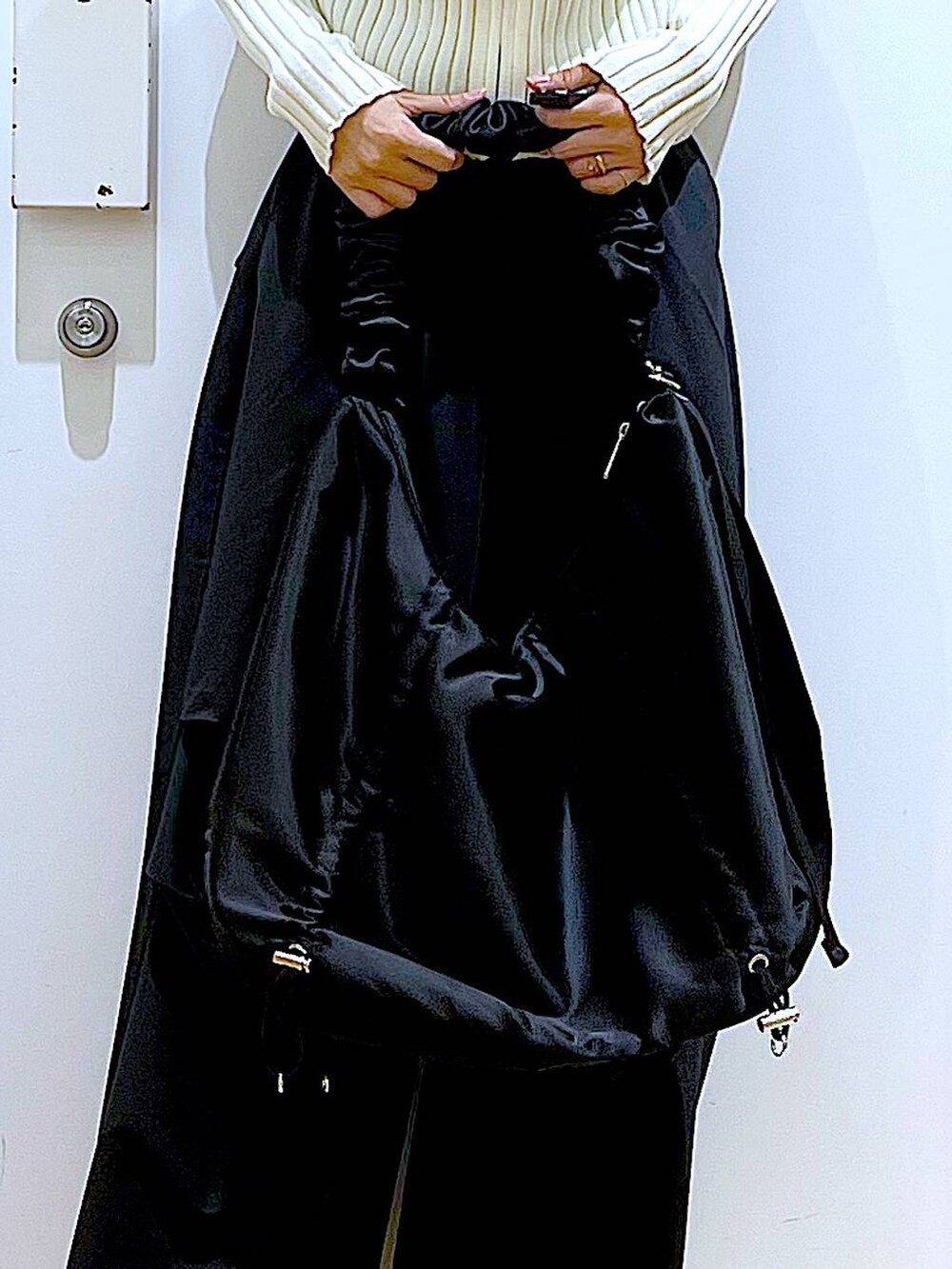 ブラック系のその他パンツ、ベージュ系のカーディガン/ボレロ、ベージュ系のブーツを着用したレディースの春コーディネートの9枚目の写真