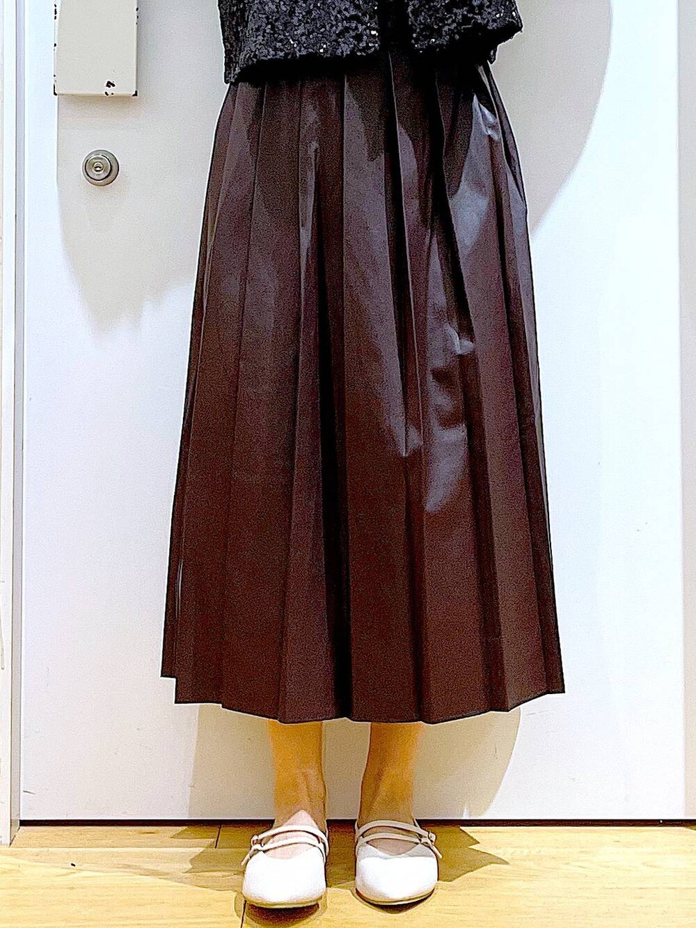 ベージュ系のショルダーバッグ、ホワイト系のパンプス、ブラック系のベストを着用したレディースの秋コーディネートの8枚目の写真