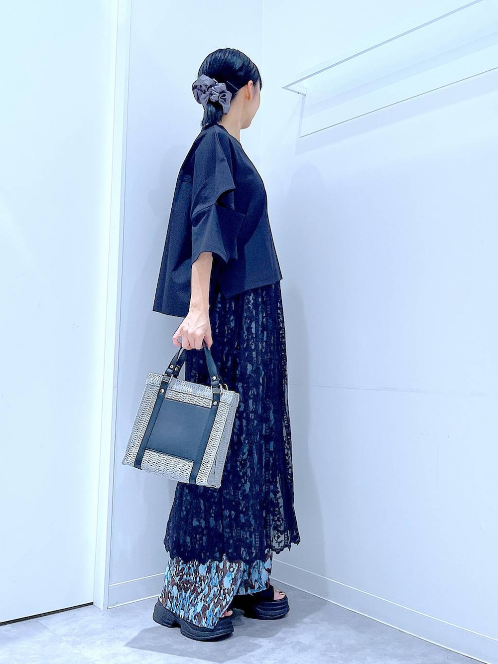 グレー系のショルダーバッグ、ブラック系のサンダル、ブラック系のTシャツ/カットソーを着用したレディースの夏コーディネートの4枚目の写真