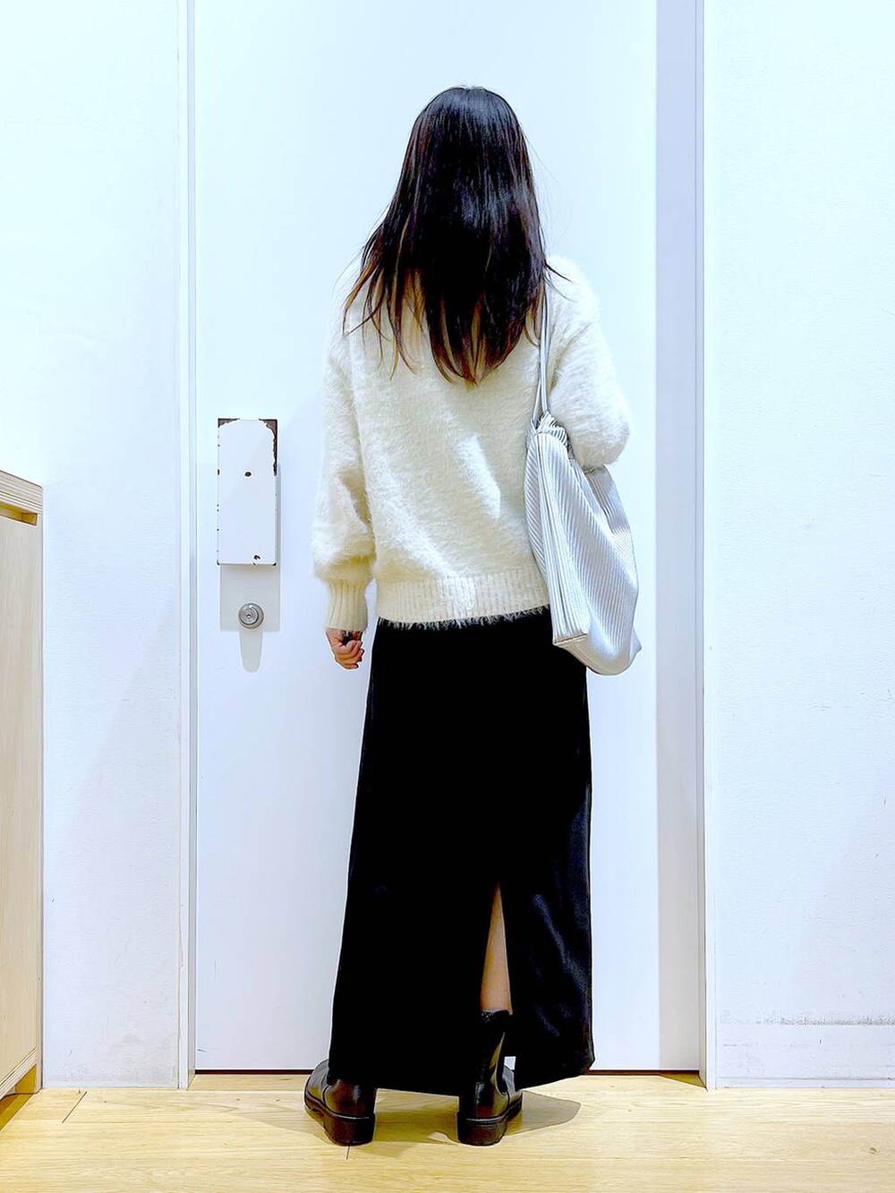 ブラック系のブーツ、シルバー系のトートバッグ、ベージュ系のニット/セーターを着用したレディースの冬コーディネートの5枚目の写真