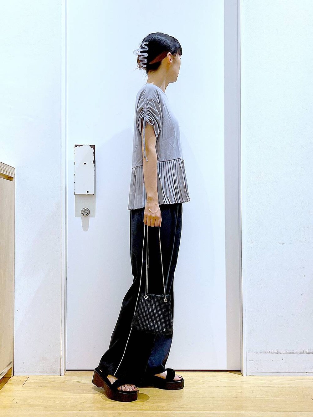 ブラック系のサンダル、ブラック系のスラックス、グレー系のTシャツ/カットソーを着用したレディースの秋コーディネートの4枚目の写真