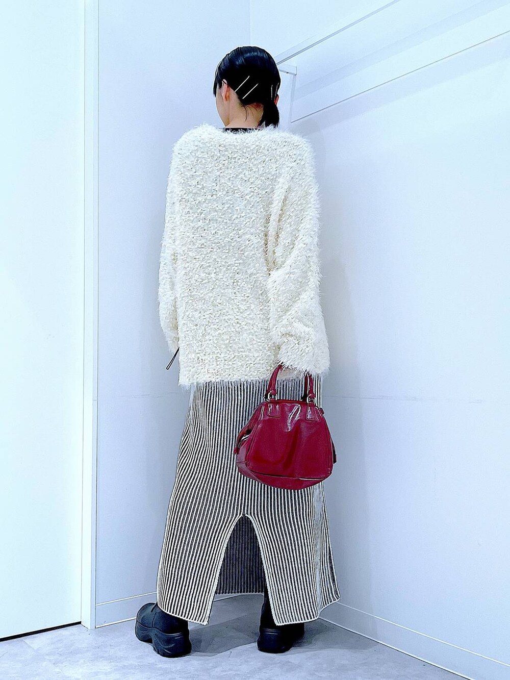 ブラック系のブーツ、ベージュ系のスカート、ベージュ系のカーディガン/ボレロを着用したレディースの秋コーディネートの5枚目の写真