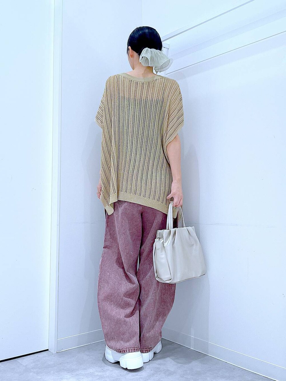 レッド系のデニムパンツ、ホワイト系のサンダル、ホワイト系のハンドバッグを着用したレディースの夏コーディネートの5枚目の写真