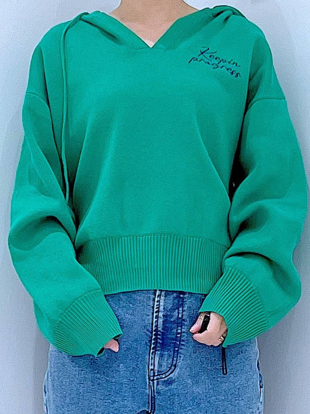 ホワイト系のショルダーバッグ、グリーン系のニット/セーター、ブルー系のデニムパンツを着用したレディースの春コーディネートの7枚目の写真