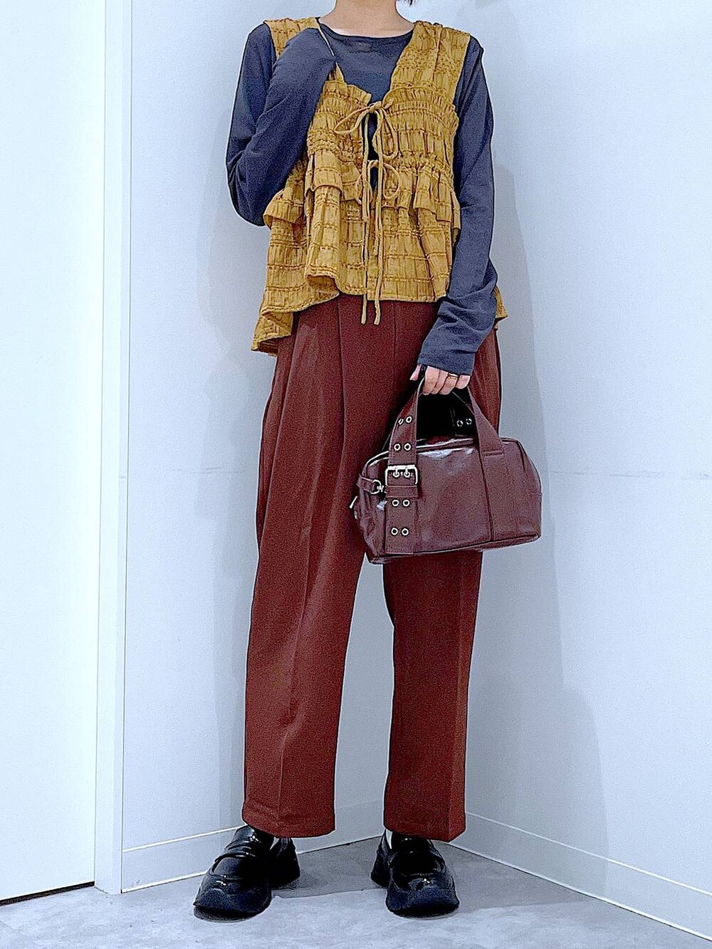 グレー系のTシャツ/カットソー、ブラック系のローファー、ブラック系のショルダーバッグを着用したレディースの秋コーディネートの6枚目の写真