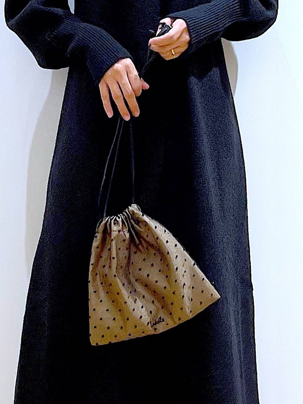 ブラック系のブーツ、ブラック系のワンピース、その他のポーチを着用したレディースの冬コーディネートの9枚目の写真