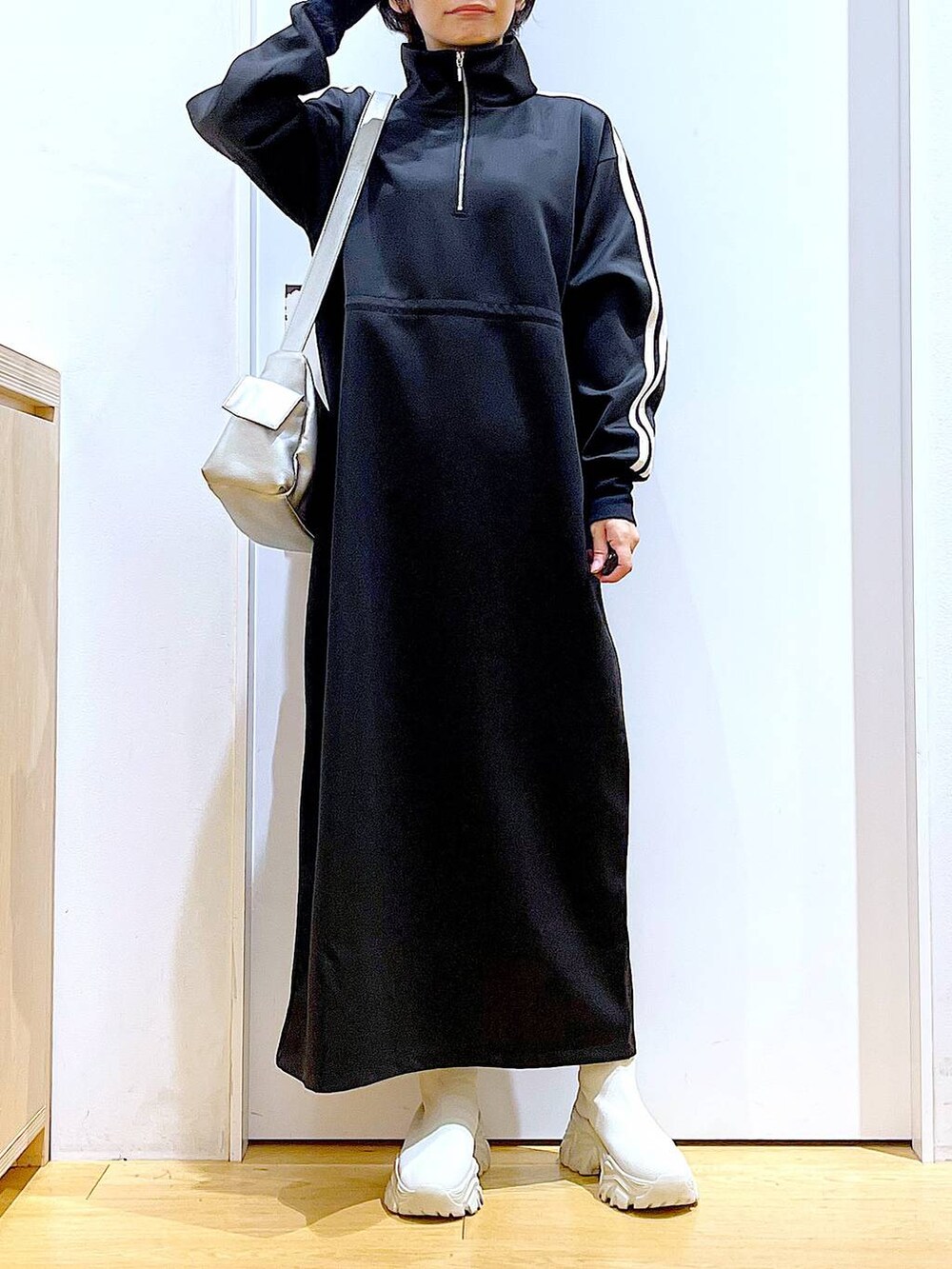 ベージュ系のブーツ、ブラック系のワンピース、その他のショルダーバッグを着用したレディースの秋コーディネートの6枚目の写真