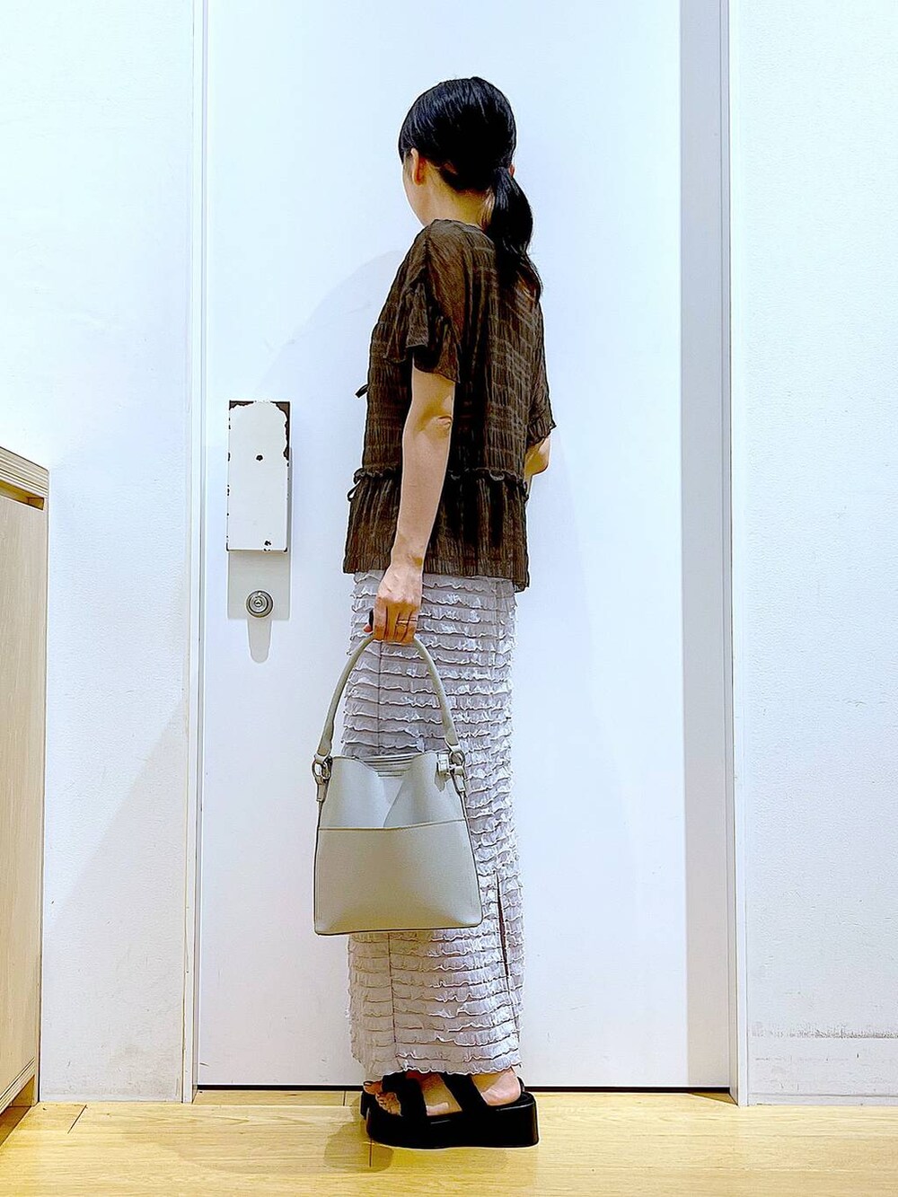 ブラック系のサンダル、グレー系のショルダーバッグ、グレー系のスカートを着用したレディースの秋コーディネートの3枚目の写真