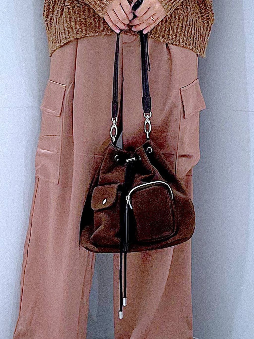 ブラウン系のニット/セーター、ブラウン系のショルダーバッグ、ブラック系のブーツを着用したレディースの冬コーディネートの9枚目の写真