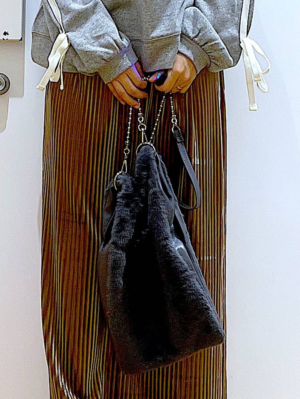 グレー系のショルダーバッグ、ブラウン系のスカート、ベージュ系のブーツを着用したレディースの秋コーディネートの9枚目の写真