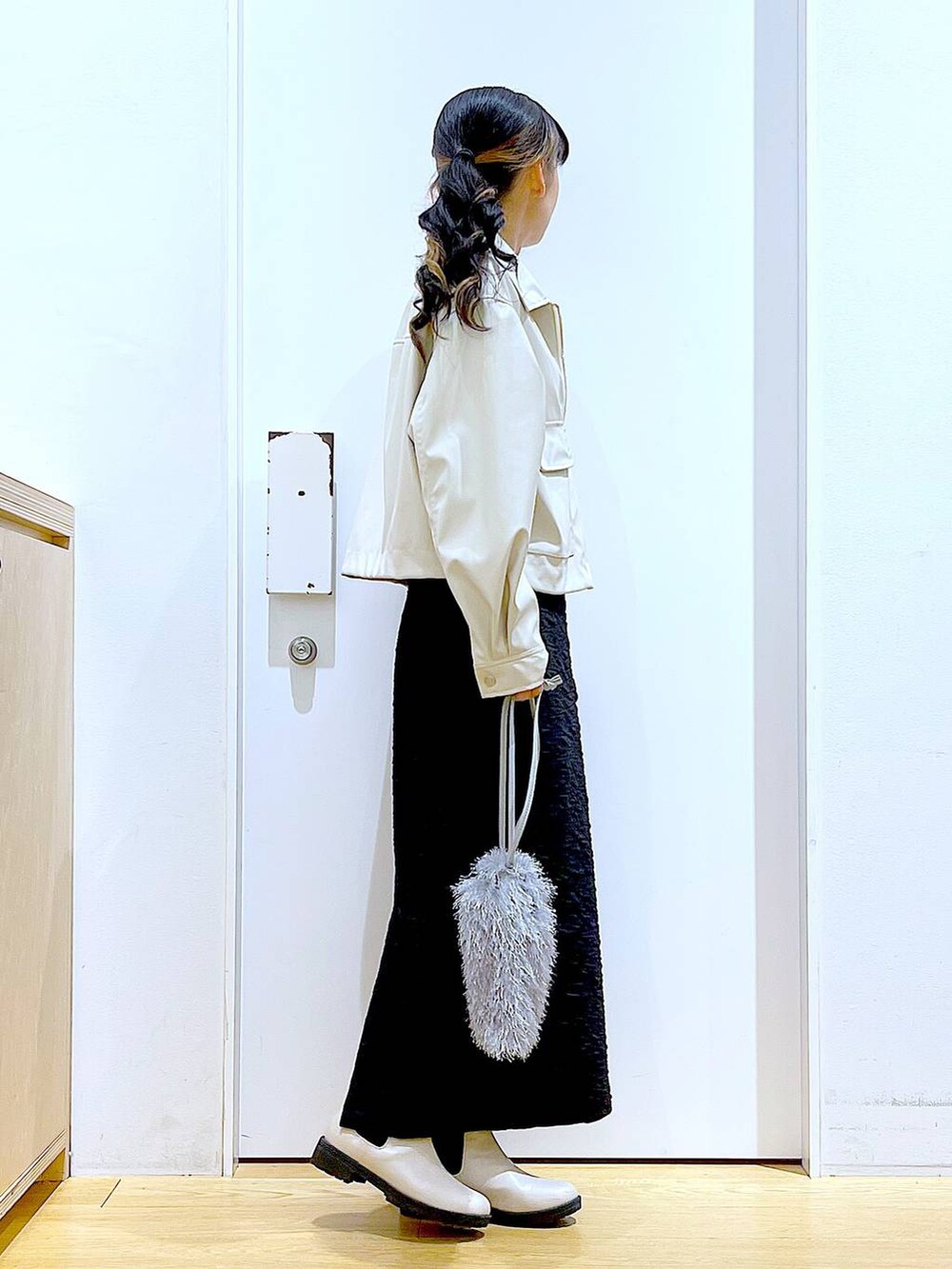 ブラック系のスカート、ベージュ系のブルゾン、ベージュ系のブーツを着用したレディースの春コーディネートの4枚目の写真