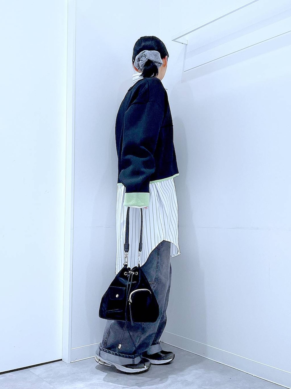 ブラック系のショルダーバッグ、ブラック系のデニムパンツ、ホワイト系のシャツ/ブラウスを着用したレディースの春コーディネートの4枚目の写真