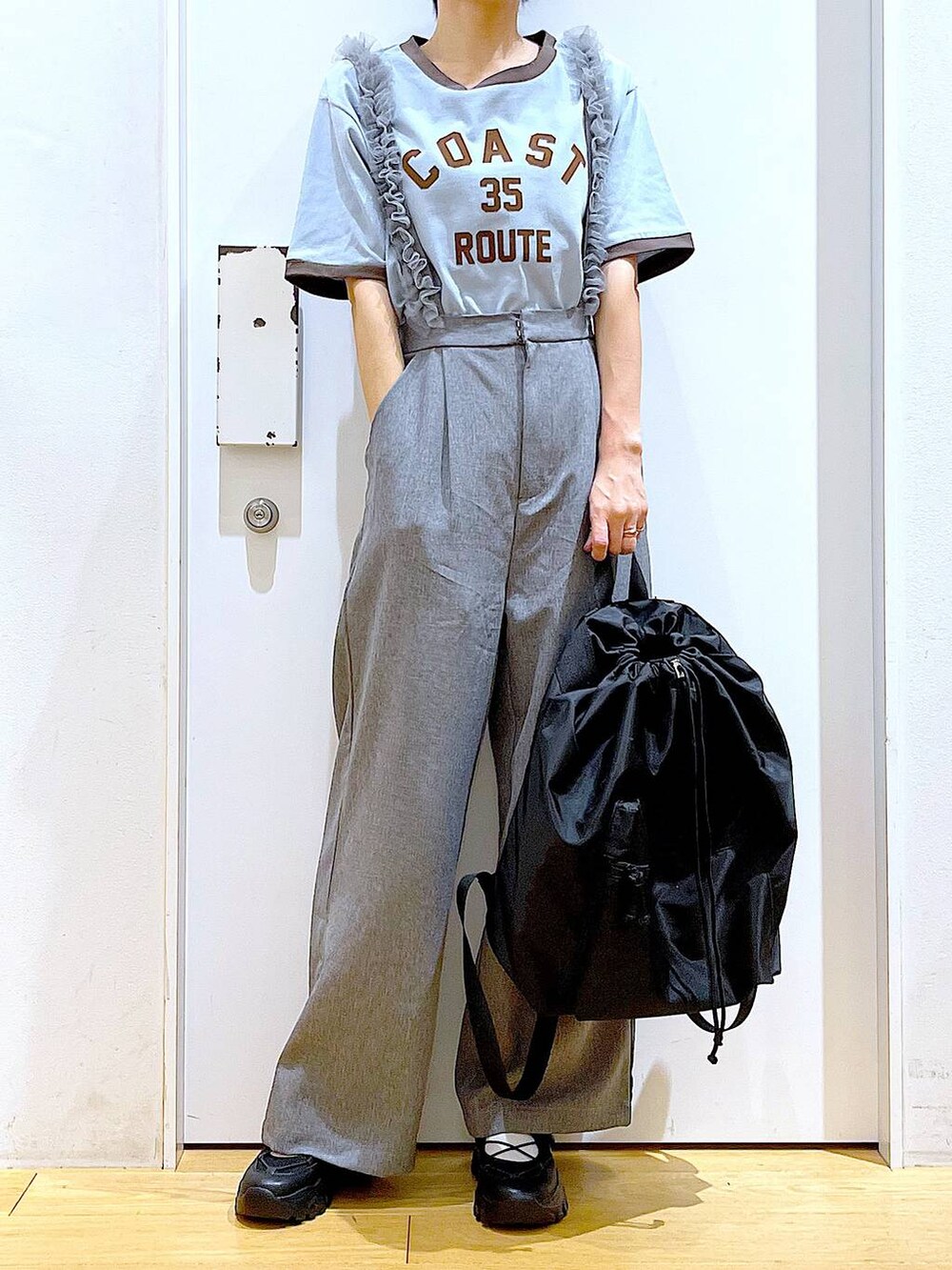 ブラック系のスニーカー、ブラック系のバックパック/リュック、グレー系のその他パンツを着用したレディースの春コーディネートの6枚目の写真