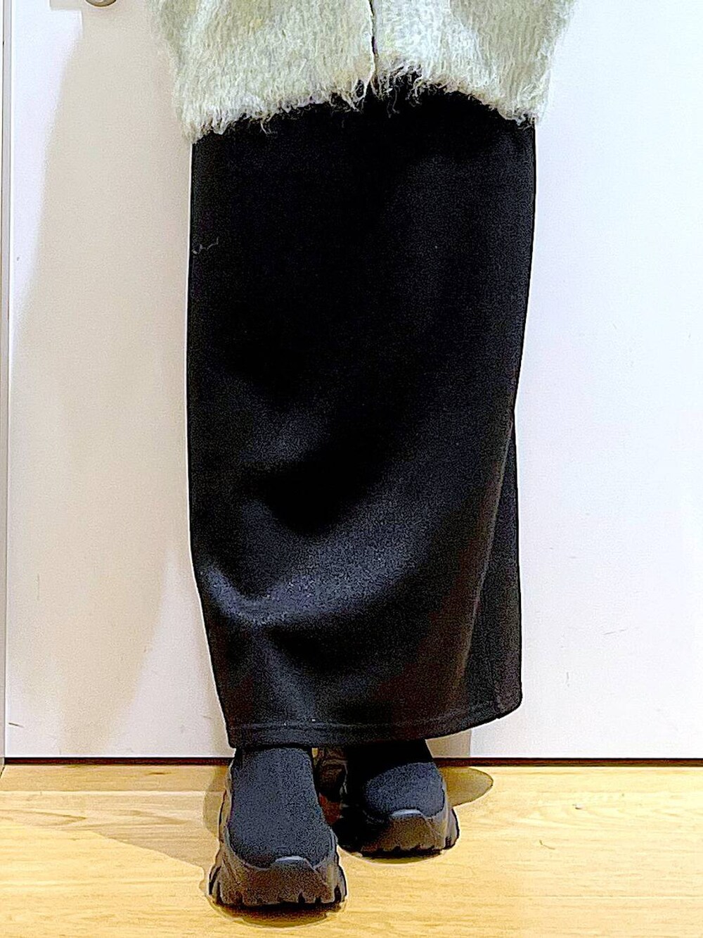 グリーン系のカーディガン/ボレロ、ブラック系のブーツ、ブラック系のスカートを着用したレディースの冬コーディネートの8枚目の写真