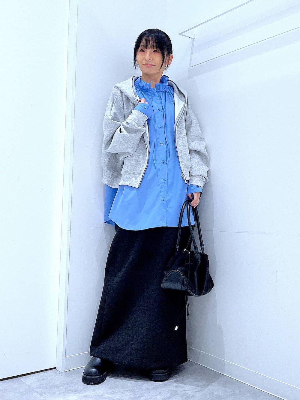 ブラック系のハンドバッグ、ブラック系のスカート、ブラック系のサンダルを着用したレディースの冬コーディネートの2枚目の写真