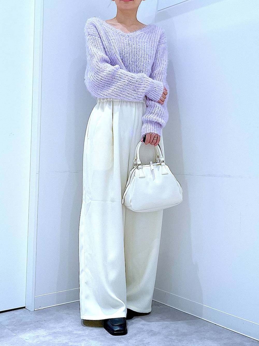 ブラック系のブーツ、ホワイト系のショルダーバッグ、パープル系のニット/セーターを着用したレディースの冬コーディネートの6枚目の写真