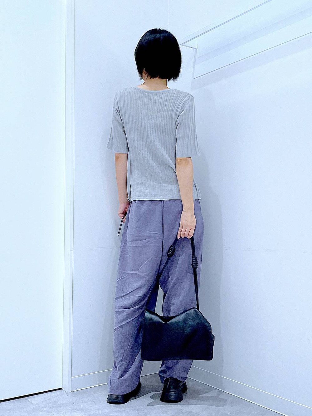 ブラック系のショルダーバッグ、ブラック系のローファー、グレー系のニット/セーターを着用したレディースの秋コーディネートの5枚目の写真