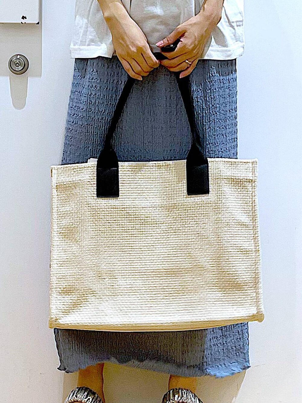 シルバー系のサンダル、ブルー系のスカート、ホワイト系のトートバッグを着用したレディースの夏コーディネートの9枚目の写真