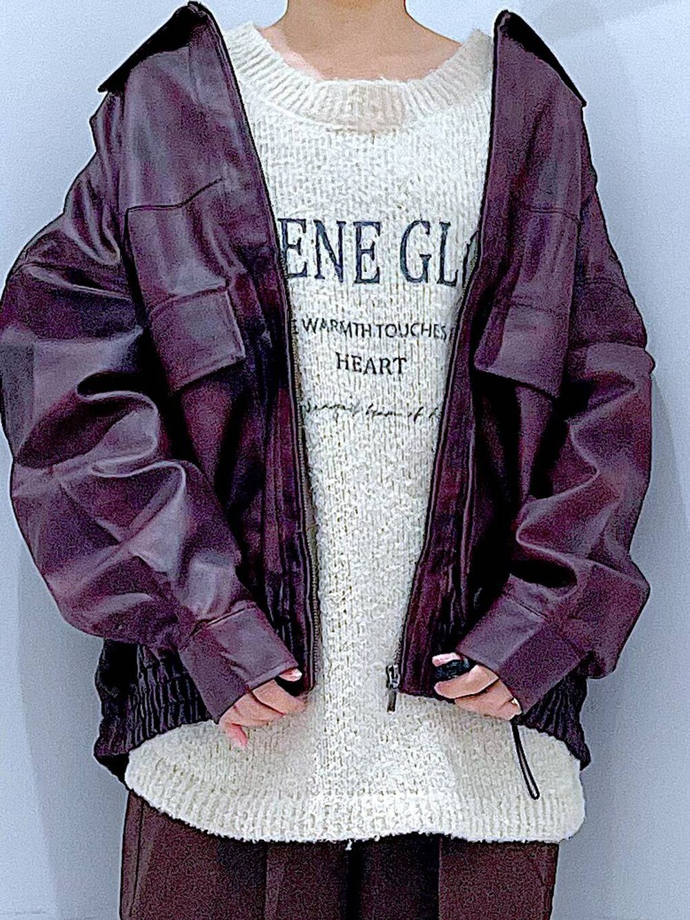 レッド系のブルゾン、ホワイト系のニット/セーター、ブラック系のブーツを着用したレディースの秋コーディネートの7枚目の写真