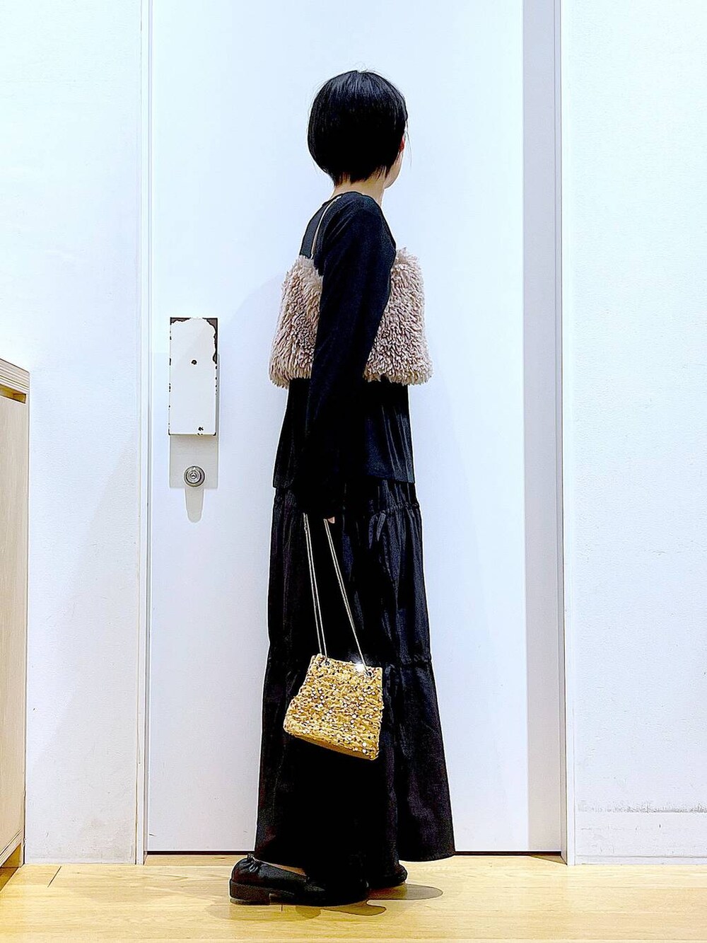 ブラウン系のベスト、ベージュ系のショルダーバッグ、ブラック系のTシャツ/カットソーを着用したレディースの秋コーディネートの4枚目の写真