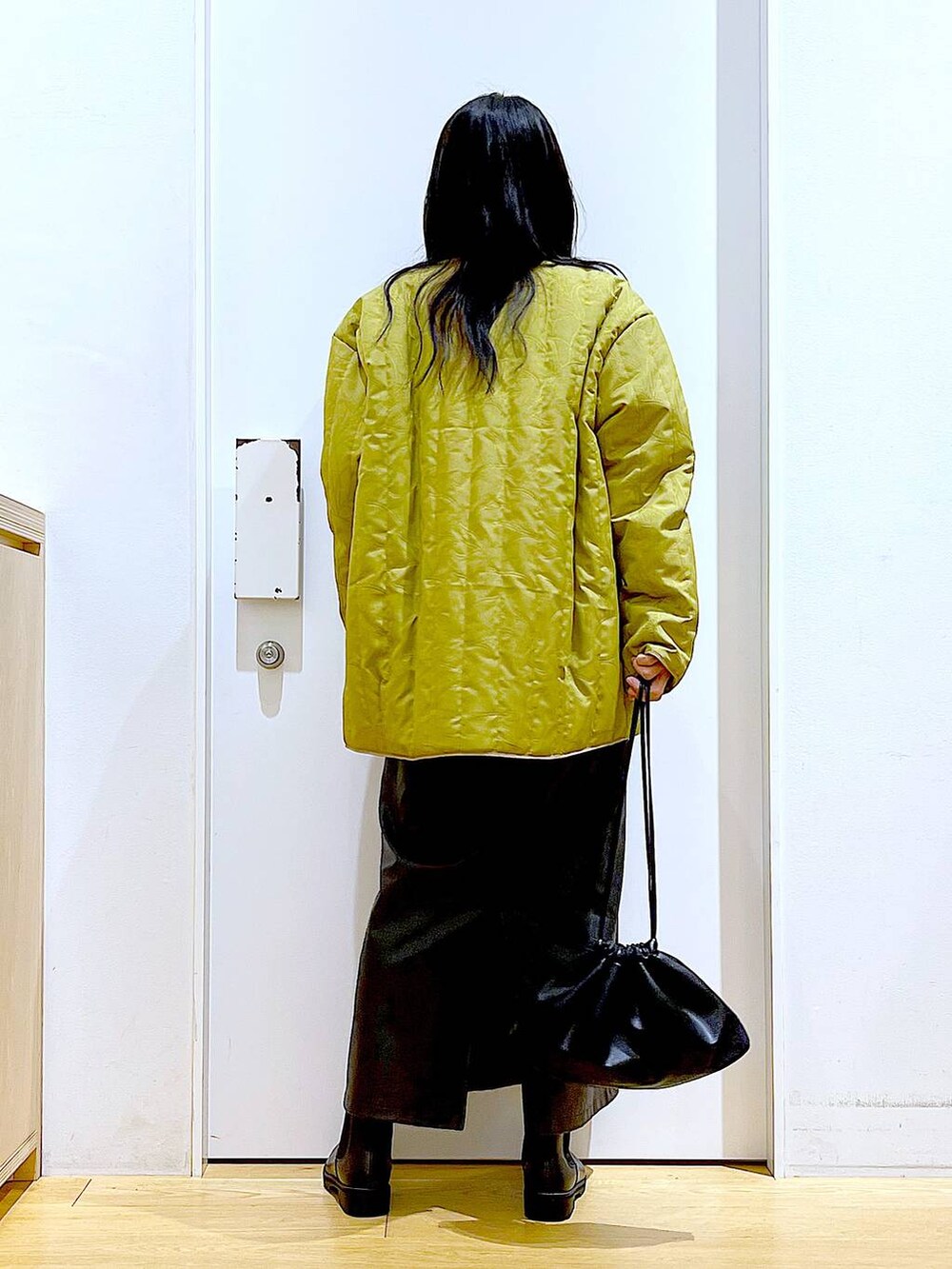 ブラック系のブーツ、ブラック系のショルダーバッグ、ブラック系のニット/セーターを着用したレディースの冬コーディネートの5枚目の写真