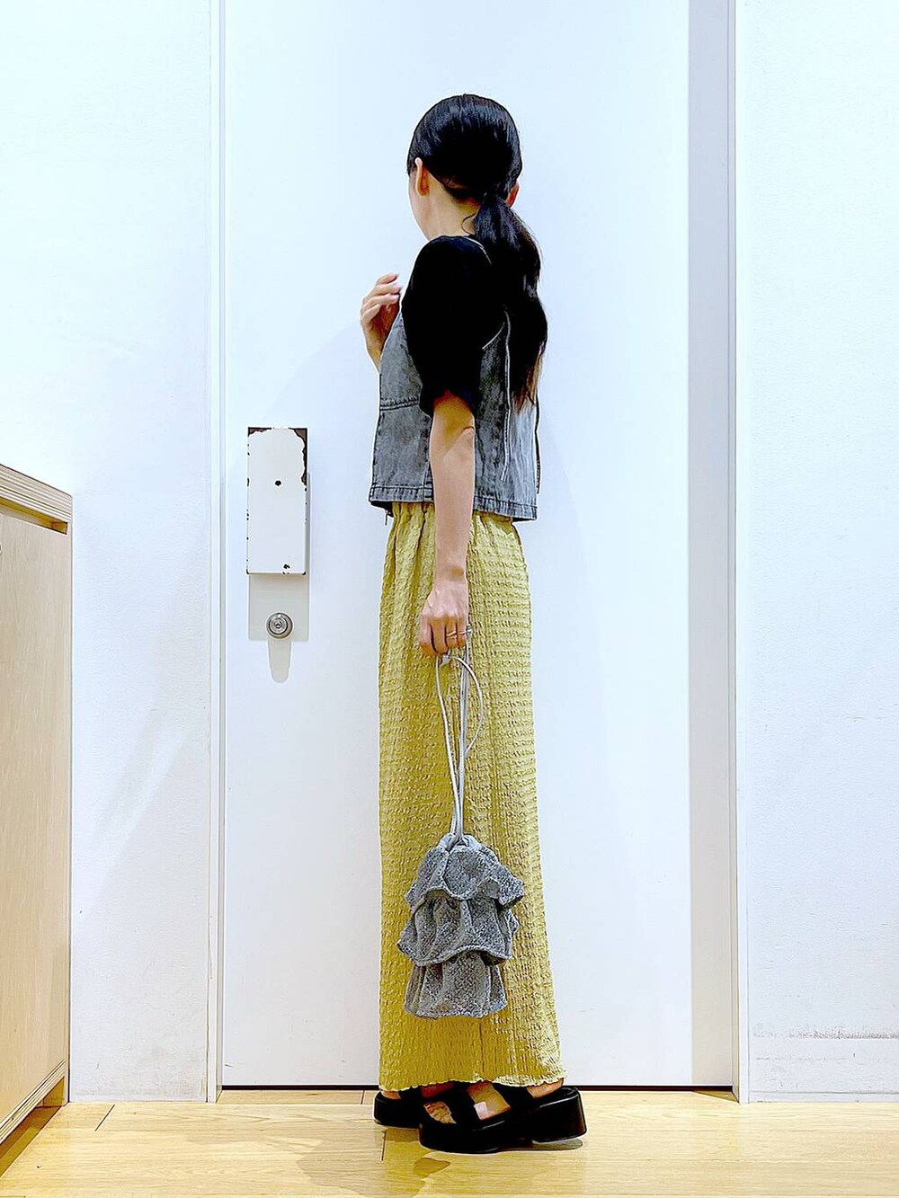 シルバー系のショルダーバッグ、グリーン系のスカート、ブラック系のTシャツ/カットソーを着用したレディースの夏コーディネートの3枚目の写真