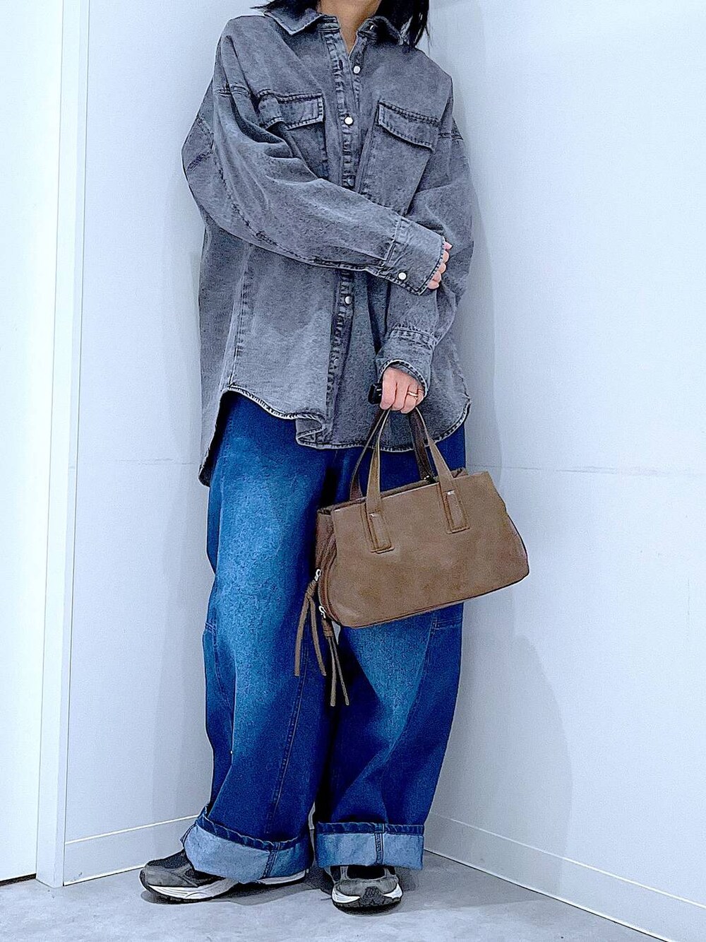 ブラウン系のボストンバッグ、ブルー系のデニムパンツ、ブラック系のシャツ/ブラウスを着用したレディースの冬コーディネートの6枚目の写真
