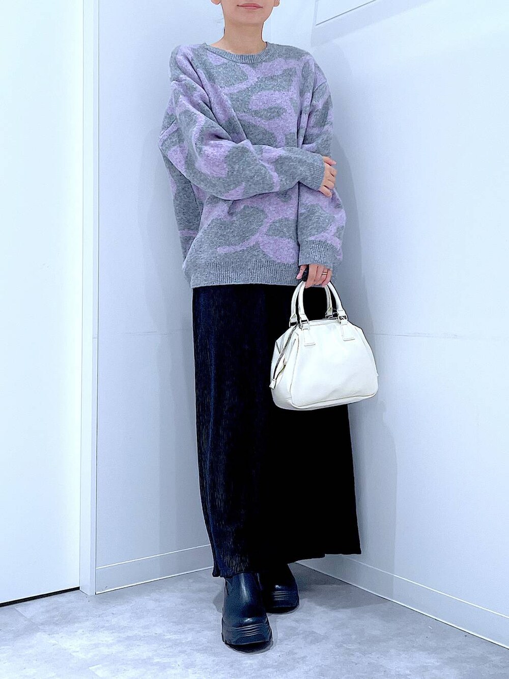 ブラック系のブーツ、グレー系のニット/セーター、ブラック系のスカートを着用したレディースの冬コーディネートの6枚目の写真