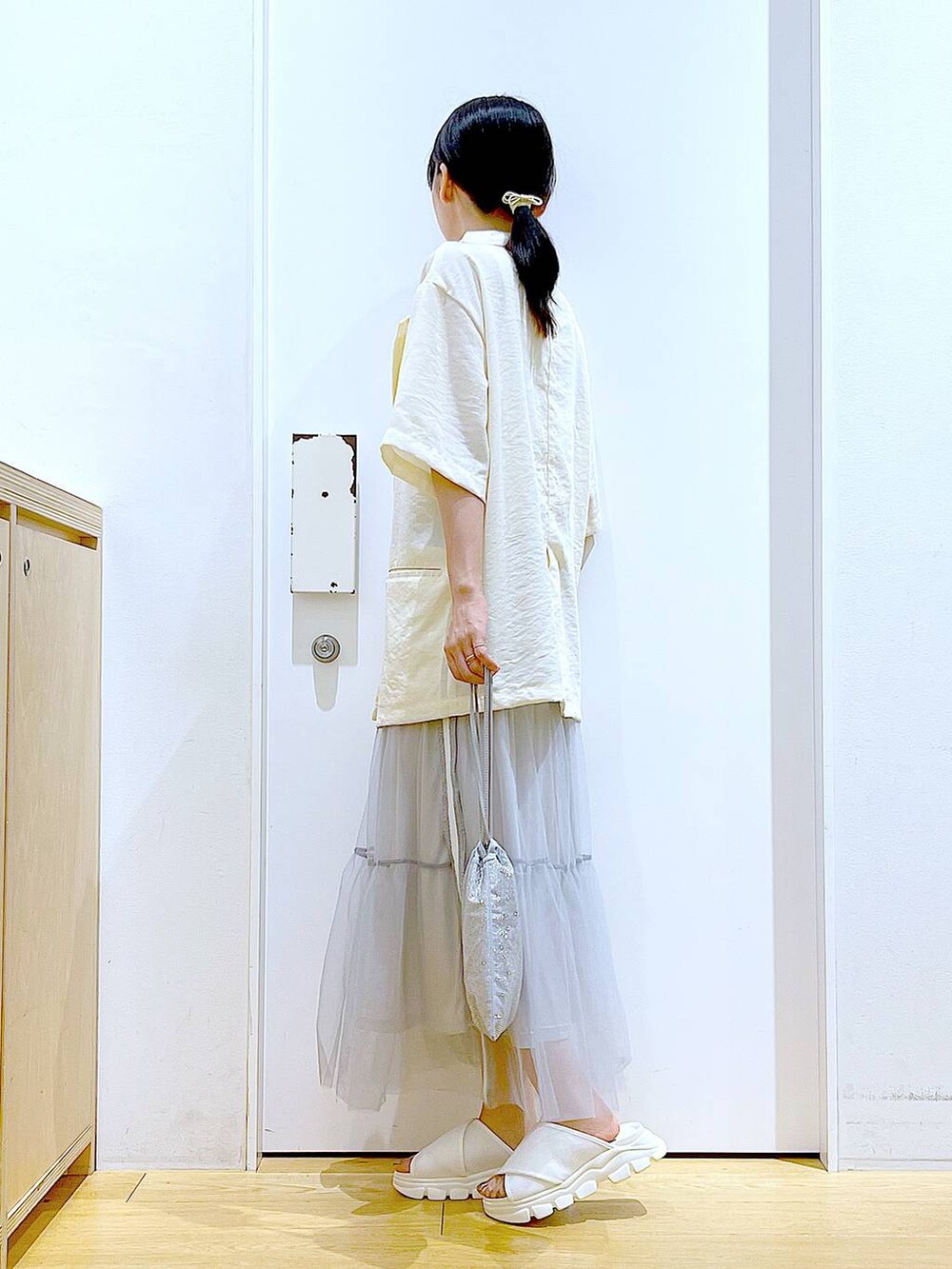 ホワイト系のサンダル、グレー系のショルダーバッグ、ホワイト系のニット/セーターを着用したレディースの夏コーディネートの3枚目の写真