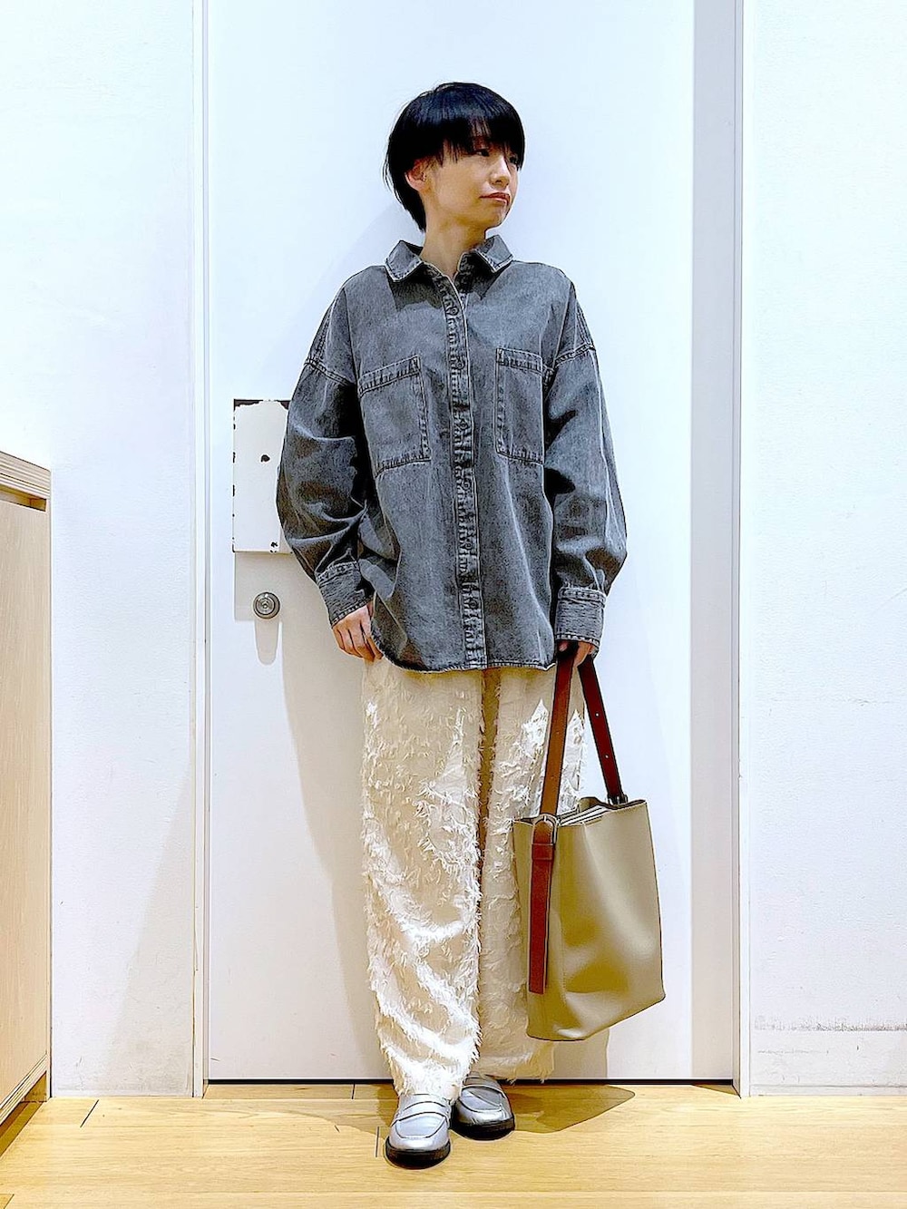 シルバー系のローファー、グレー系のシャツ/ブラウス、ベージュ系のショルダーバッグを着用したレディースの春コーディネートの2枚目の写真