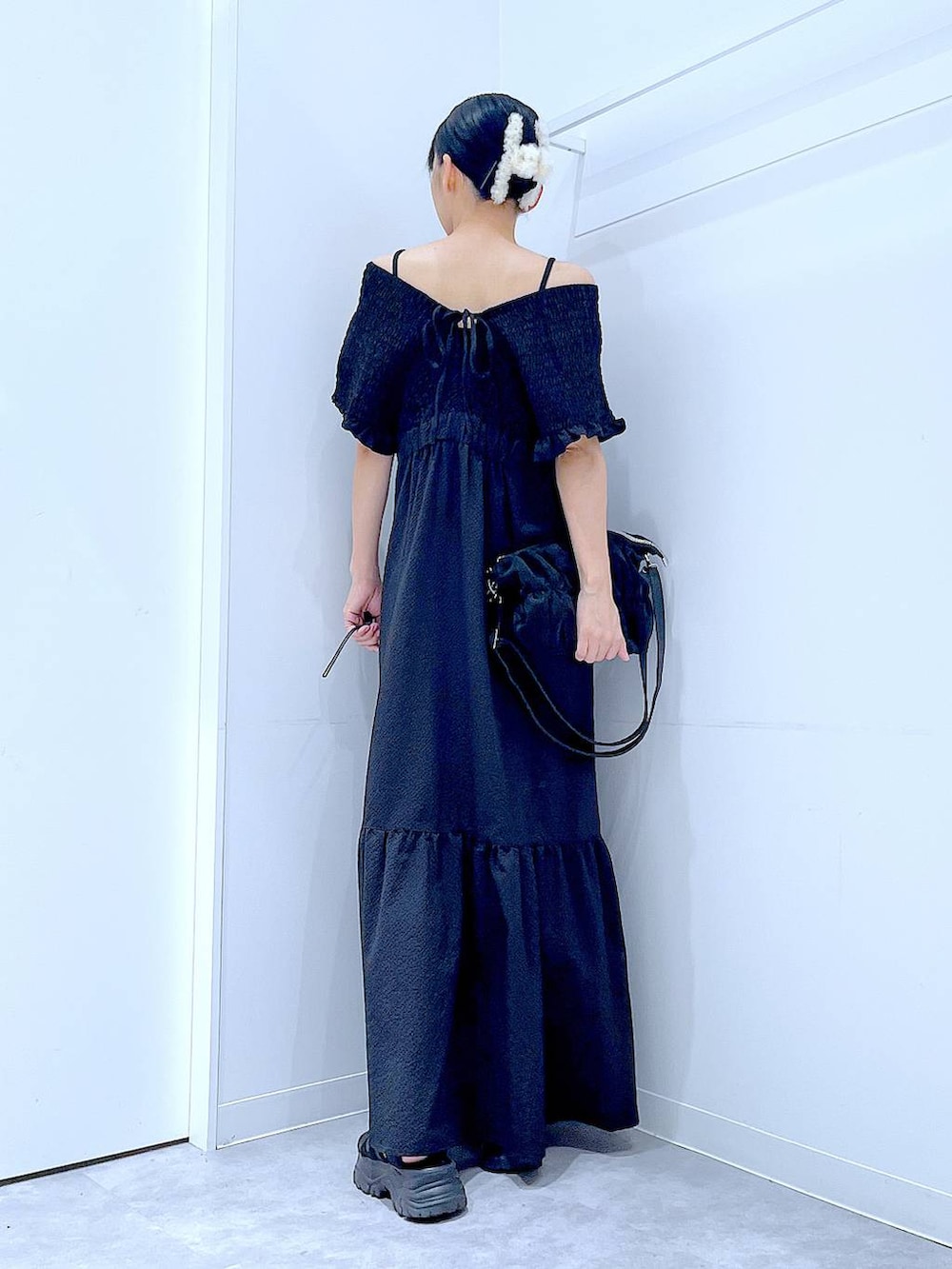 ブラック系のワンピース、ブラック系のショルダーバッグ、ホワイト系のバレッタ/ヘアクリップを着用したレディースの夏コーディネートの5枚目の写真