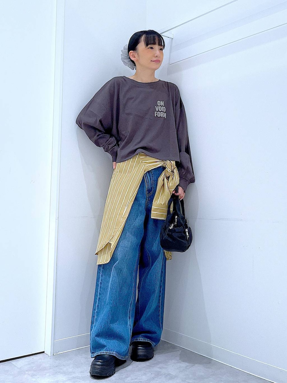 ブルー系のデニムパンツ、イエロー系のシャツ/ブラウス、グレー系のTシャツ/カットソーを着用したレディースの秋コーディネートの2枚目の写真