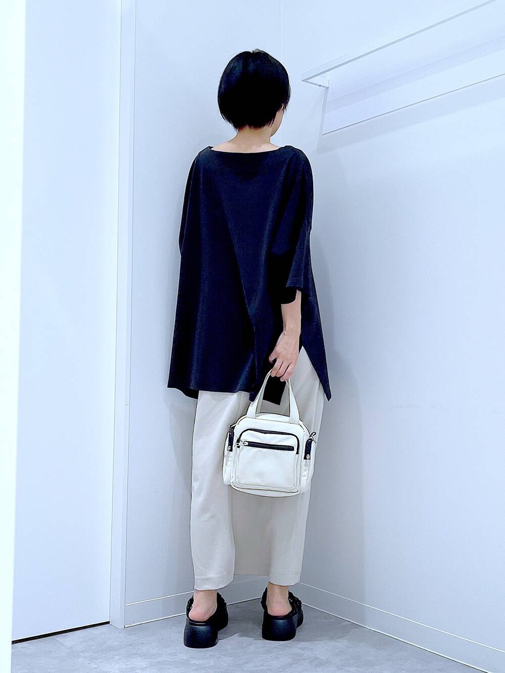 ブラック系のサンダル、ベージュ系のスカート、ホワイト系のショルダーバッグを着用したレディースの夏コーディネートの5枚目の写真