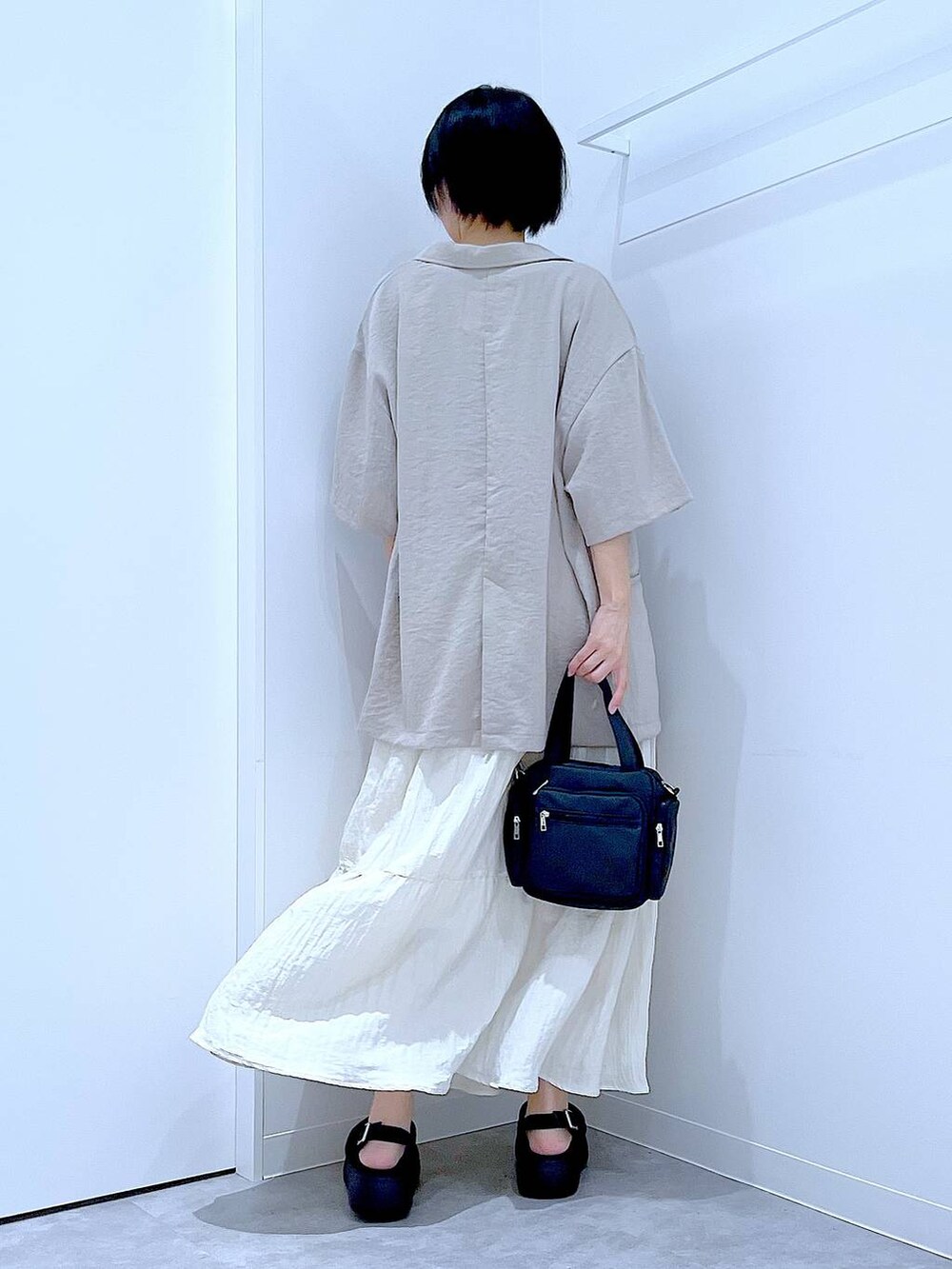 ブラック系のサンダル、ベージュ系のテーラードジャケット、ブラック系のショルダーバッグを着用したレディースの夏コーディネートの5枚目の写真