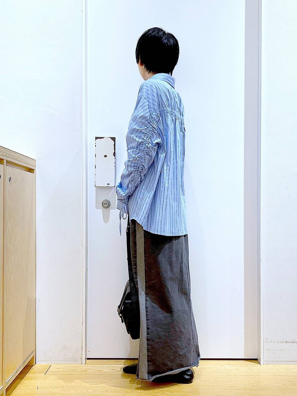 ブラック系のパンプス、ブラック系のデニムスカート、ブラック系のショルダーバッグを着用したレディースの春コーディネートの3枚目の写真