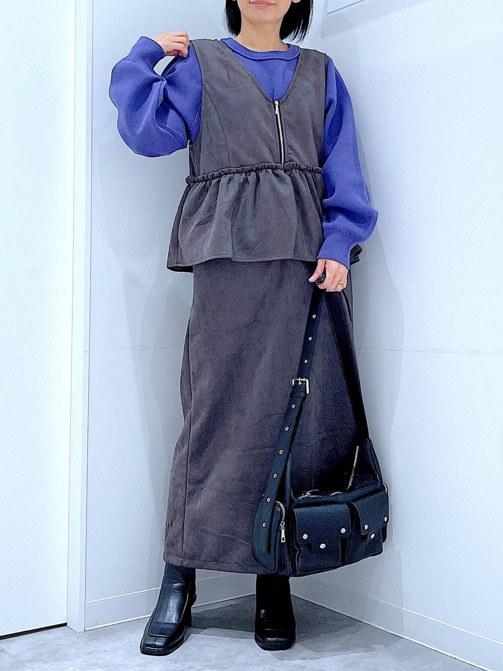 ブラック系のショルダーバッグ、ブルー系のニット/セーター、ブラック系のブーツを着用したレディースの秋コーディネートの6枚目の写真