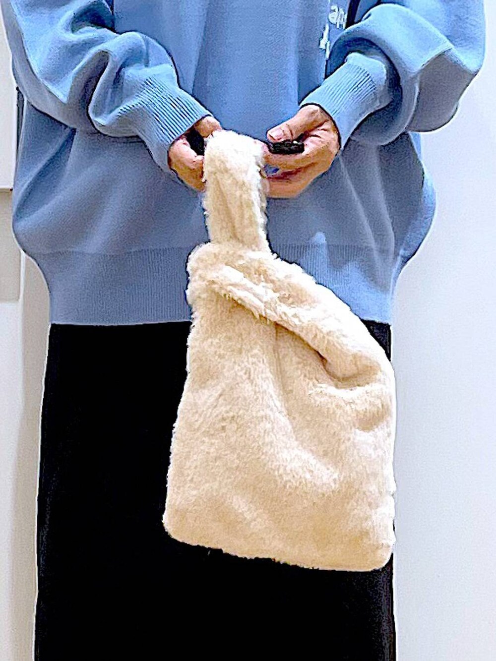 ブルー系のニット/セーター、ホワイト系のショルダーバッグ、ベージュ系のブーツを着用したレディースの冬コーディネートの9枚目の写真