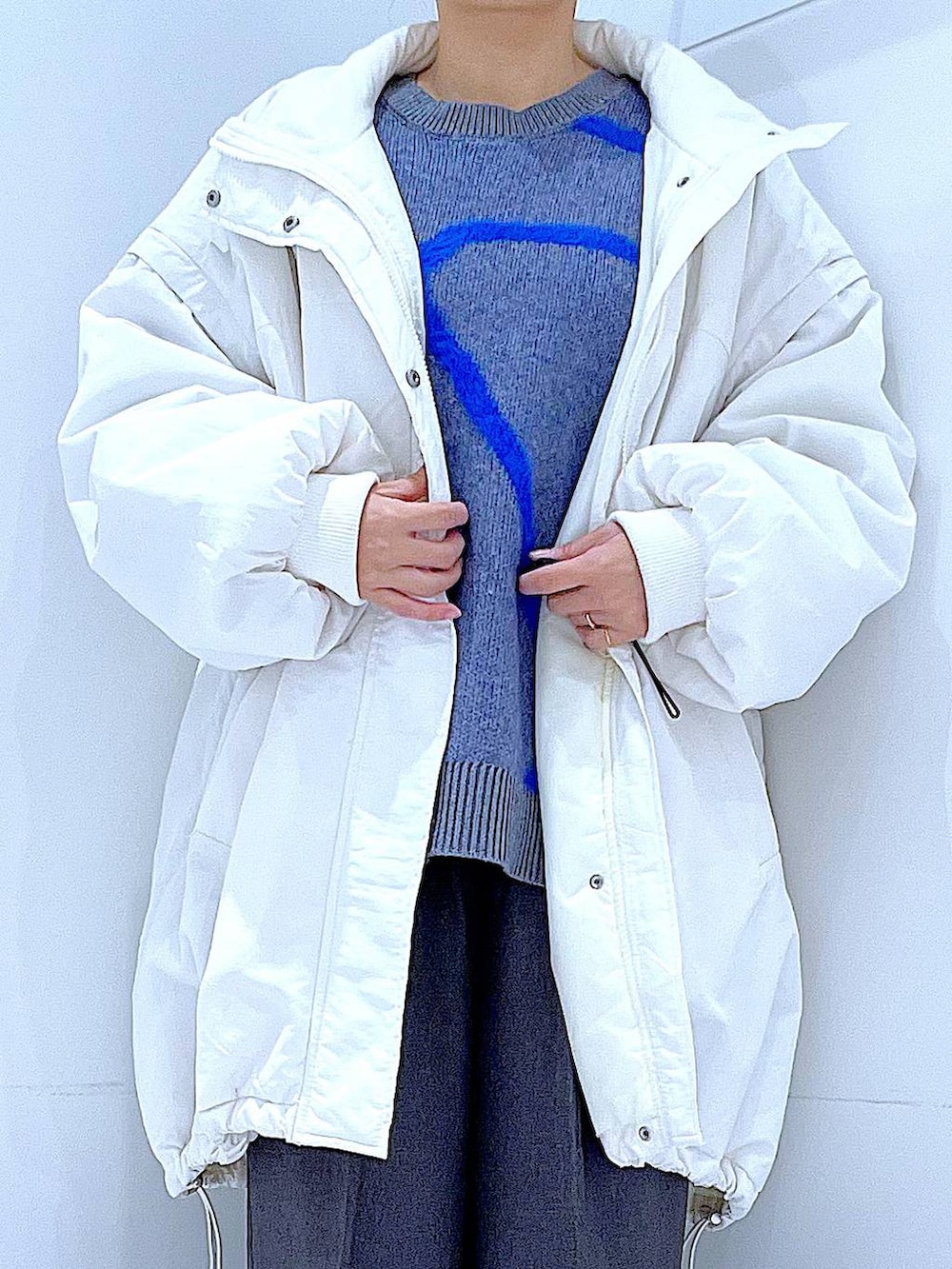 ホワイト系のブルゾン、ホワイト系のショルダーバッグ、ブラック系のブーツを着用したレディースの冬コーディネートの7枚目の写真